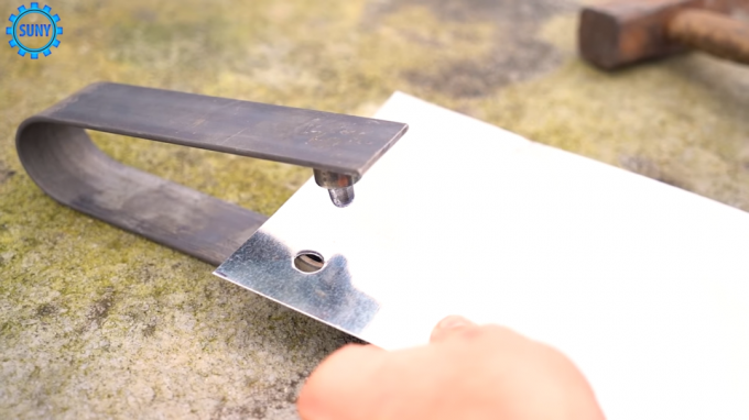 O processo de fazer orifícios na folha de metal por meio de um instrumento caseiro