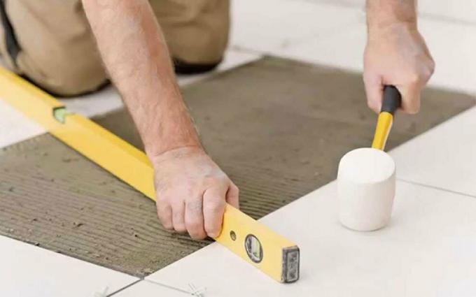 Use um nível e um martelo de borracha durante a instalação de telhas